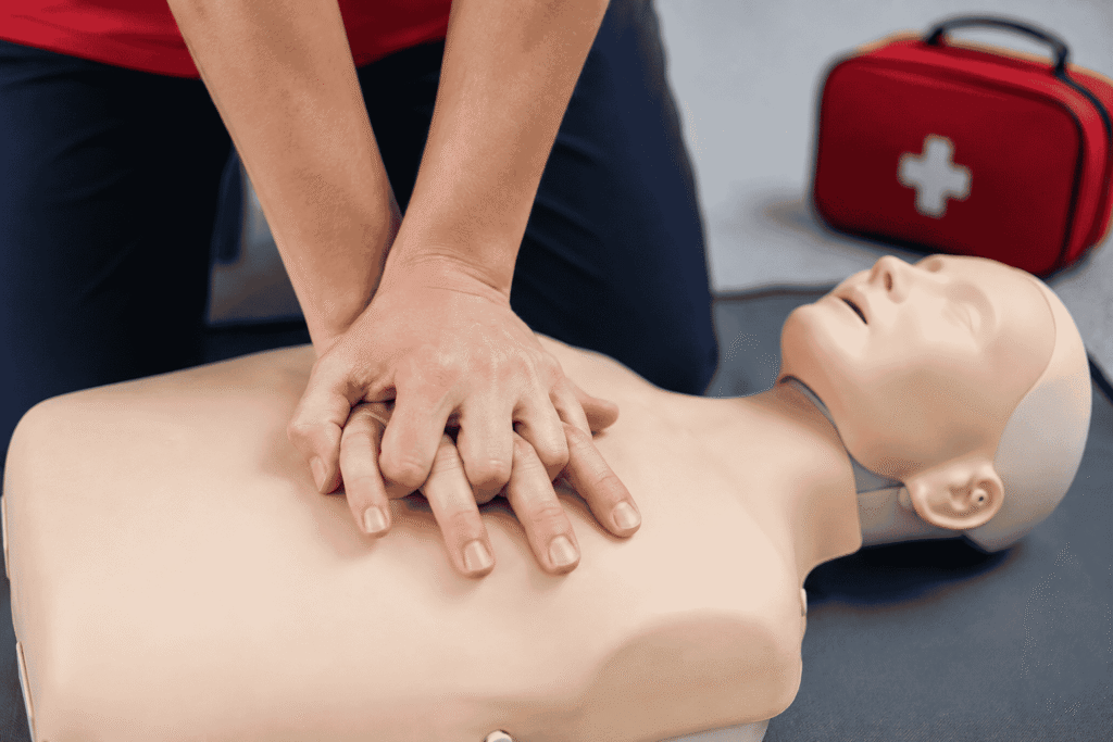 Close-up of hands positioned correctly for CPR chest compressions on a manikin or training dummy. Alt text Correct hand placement for CPR chest compressions.png